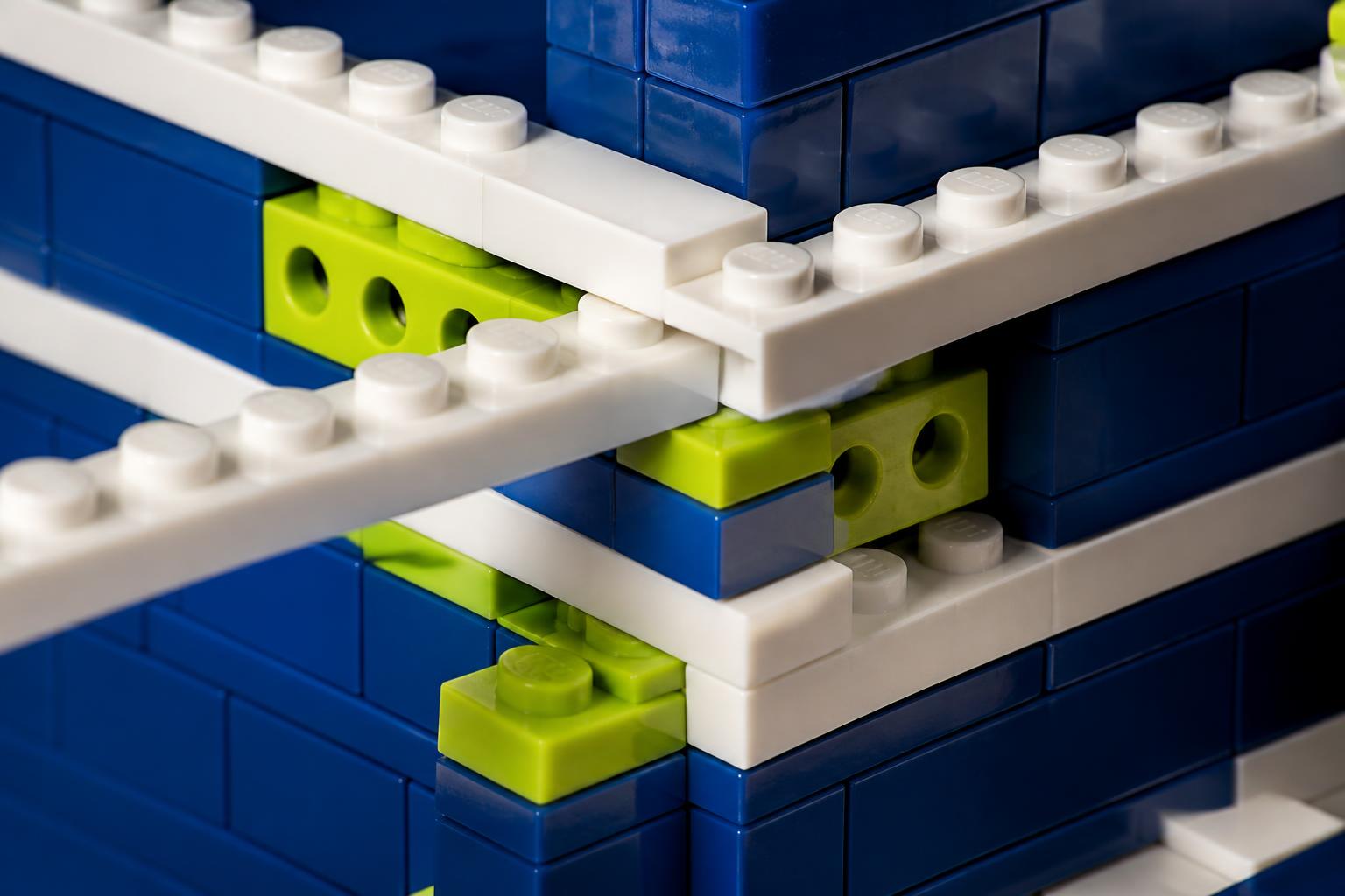 Close-up of overlapping binding plates and cross-bracing at a brick wall corner joint